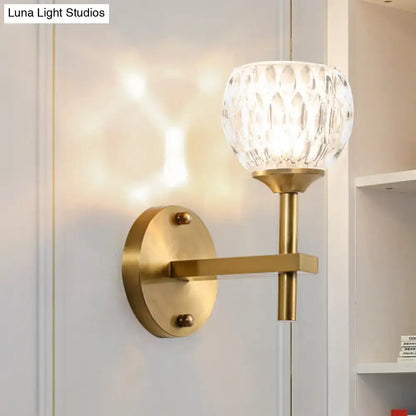 Modern black and gold wall light with brass finish and faceted dimpled glass shade for living room lighting