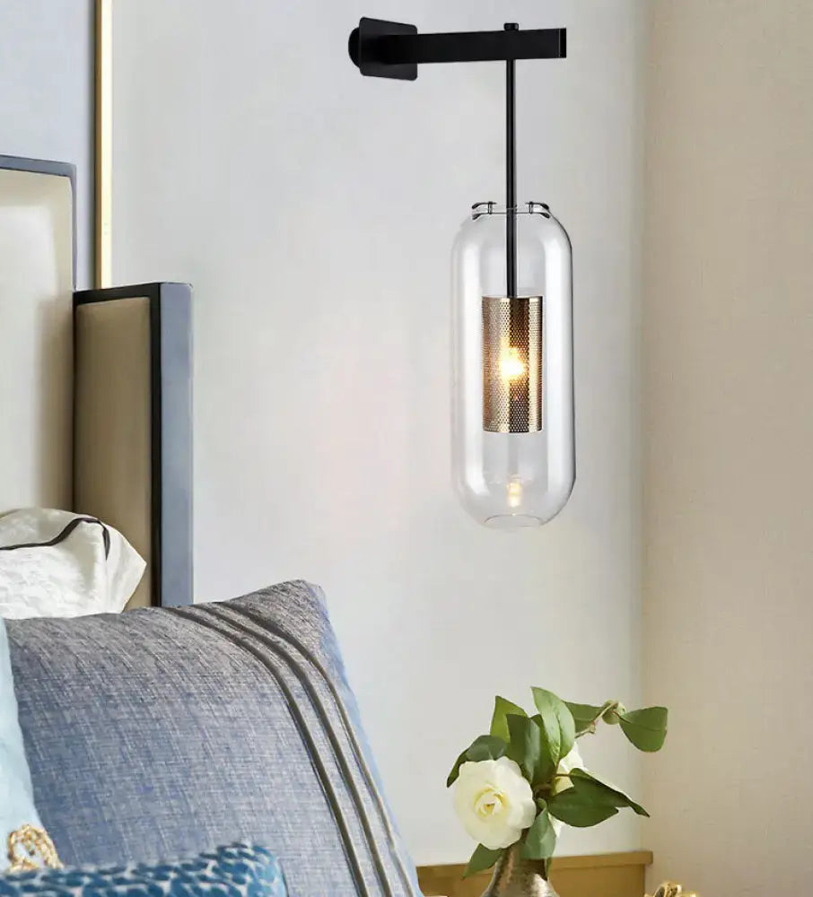 Modern black and gold wall mounted light with clear glass cylinder and textured gold-toned inner sleeve for living room