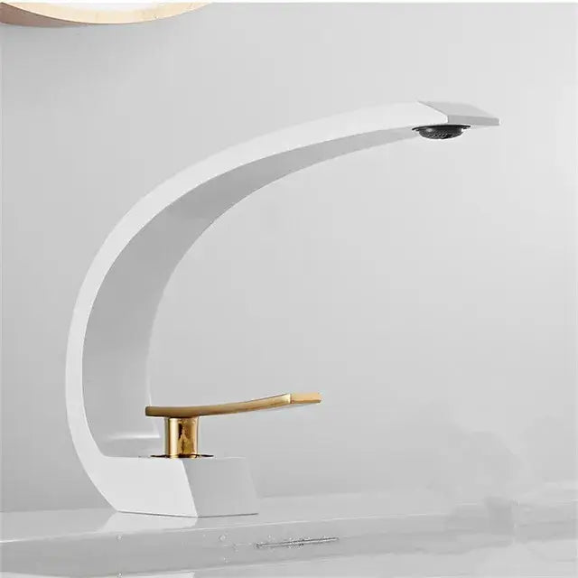 Modern black gold basin faucet with white ceramic body and sleek curved design featuring gold tone handle by decorbites