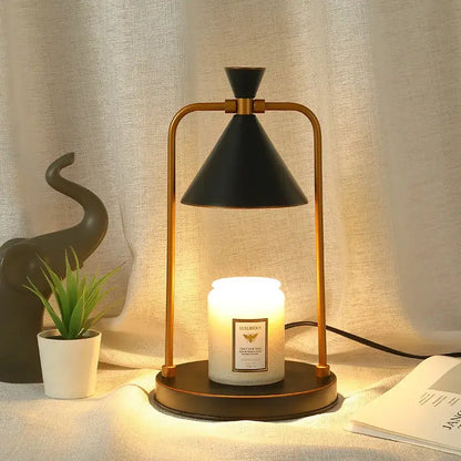 A sleek black and gold decorbites candle warmer lamp with a conical shade holding an illuminated white scented candle