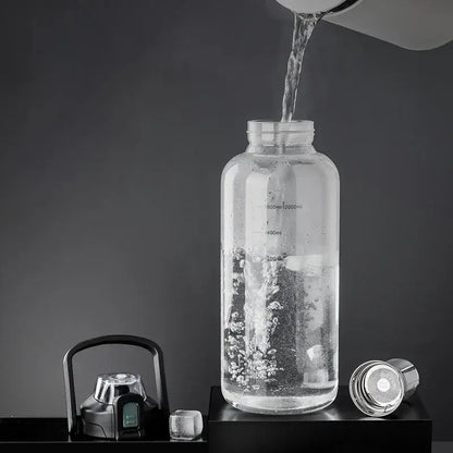 Modern black and green decorbites glass cup with clear glass water bottle, measurement markings, black lid, and metal filter