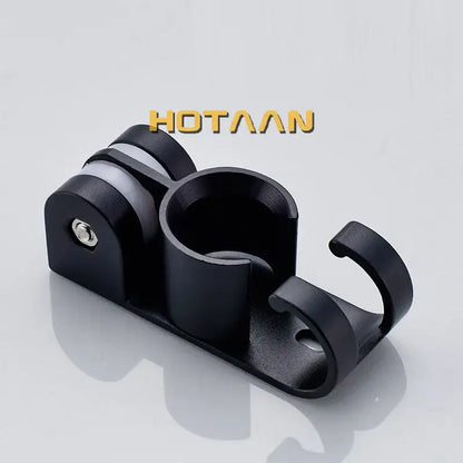 Modern black hand shower holder wall mount bracket with multi-hook organizer and central cup with silver screw detail