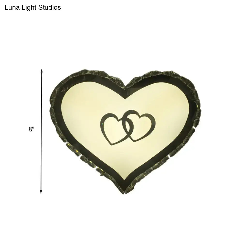 Modern black heart crystal shade wall sconce with textured dark frame and interlocking black heart design on cream light