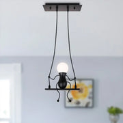 Modern black metal creative pendant light shaped like a whimsical humanoid figure holding a glowing bulb for bedroom