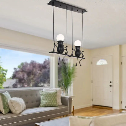 Modern black metal pendant light with two whimsical humanoid arms holding spherical bulbs for bedroom use