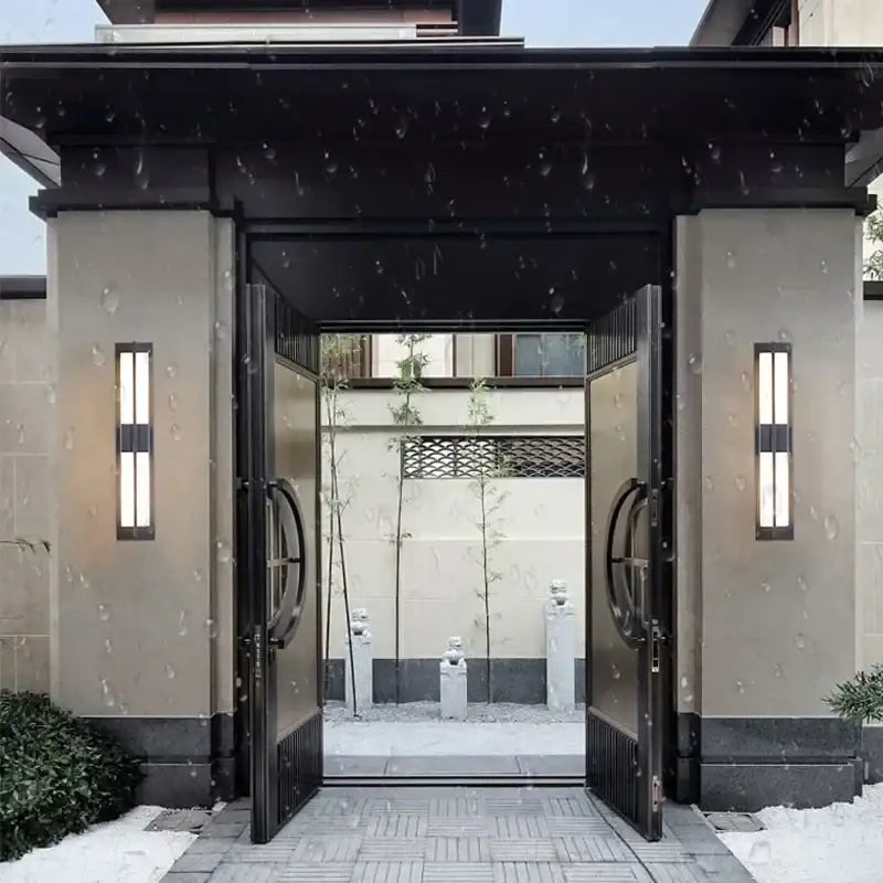 Modern black imitation marble led wall light garden sconce with vertical fixtures beside black metal double doors and circular handles
