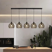 Modern black iron cage pendant lamp with intricate circular design hanging above kitchen island lighting decorbites crystal dining