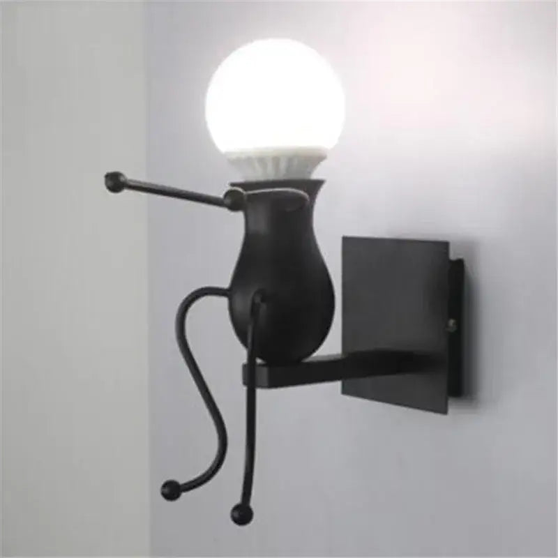 Modern black iron cartoon doll wall sconce with articulated limbs and spherical bulb head for kids bedroom decorbites cartoon doll wall