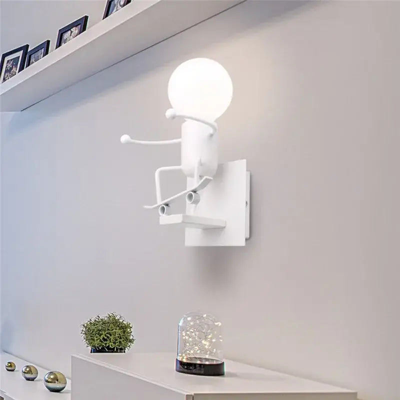 Modern black iron cartoon doll wall sconce with white minimalist spherical bulb and sculpted metal arms for kids bedroom decorbites cartoon doll wall