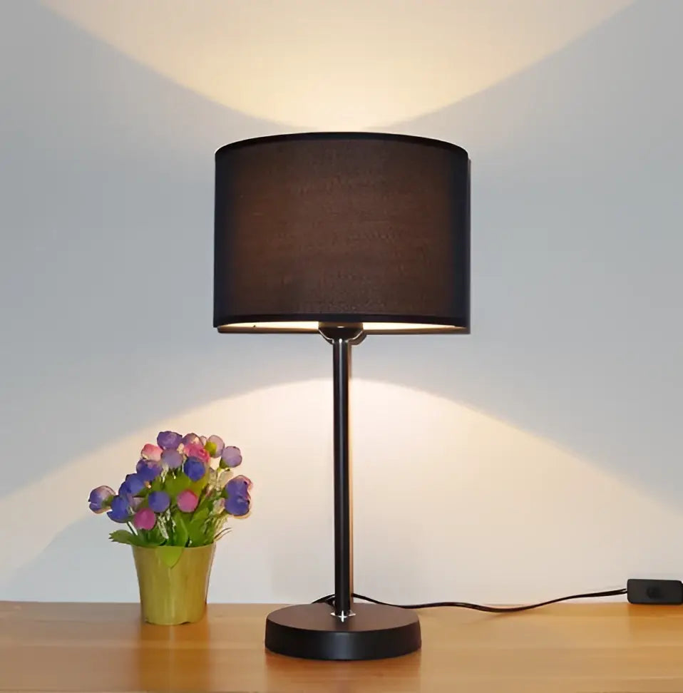 Modern black iron table lamp with fabric shade and sleek metal base casting warm light for bedroom decorbites iron table