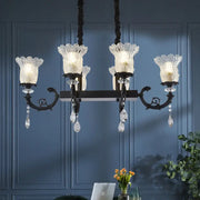 Elegant modern black island pendant lamp with black finish, clear crystal droplets, and frosted glass flower shades