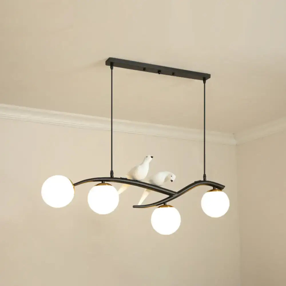 Black metal DecorBites™ island pendant light with three white frosted glass bulbs and ceramic bird accents for dining room