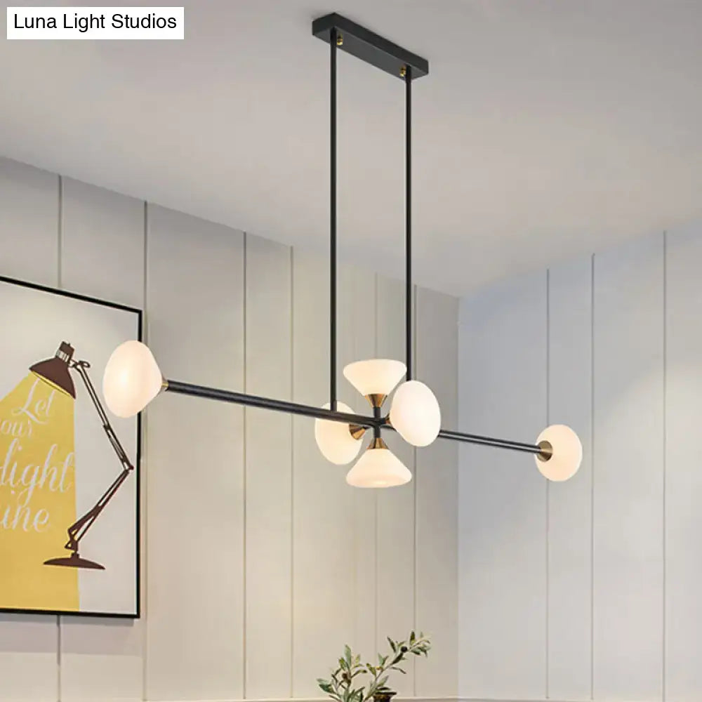 Modern black metal chandelier with five frosted glass globes and brass accent for use as island pendant ceiling light