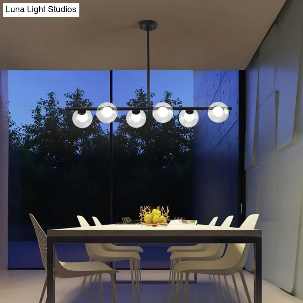 Modern black island pendant with five frosted glass globe bulbs featuring clear glass accents for dining room lighting