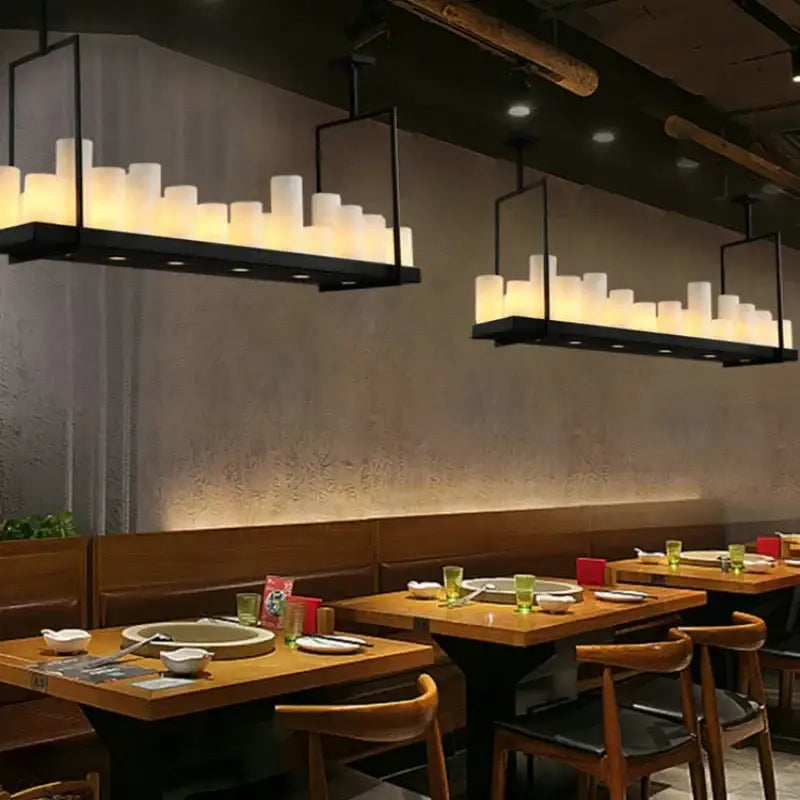 Modern black led chandelier with glass led hanging light fixtures and warm glowing bulbs in a dining room setting