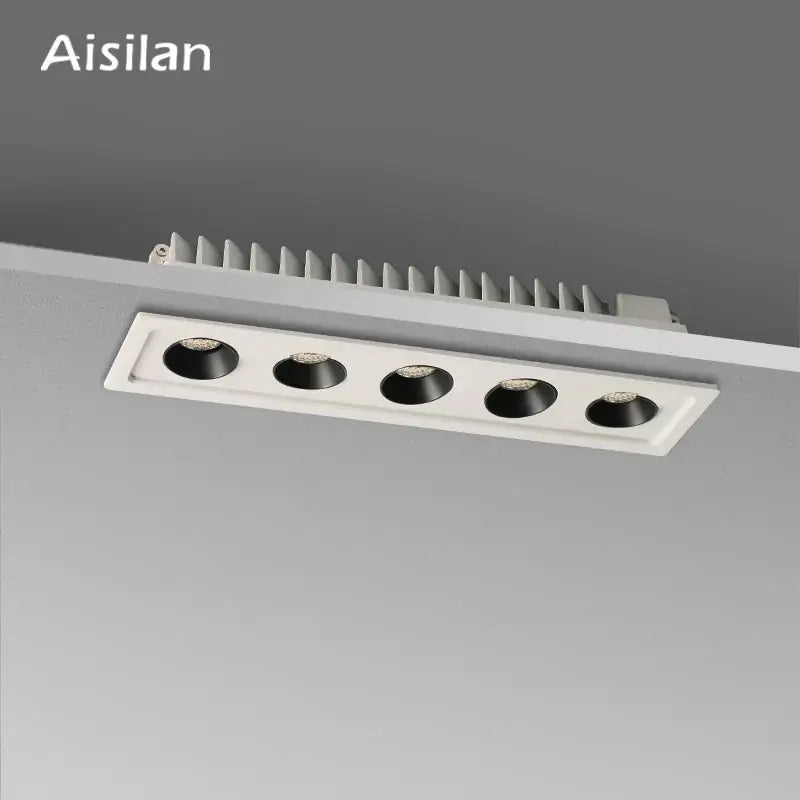 Modern black led grille downlight with five black circular led spots in a white rectangular recessed ceiling fixture