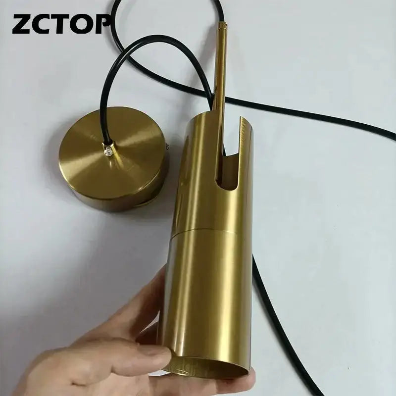 Gold finished cylindrical pendant light with black cord featuring a modern led spotlight chandelier design for living rooms