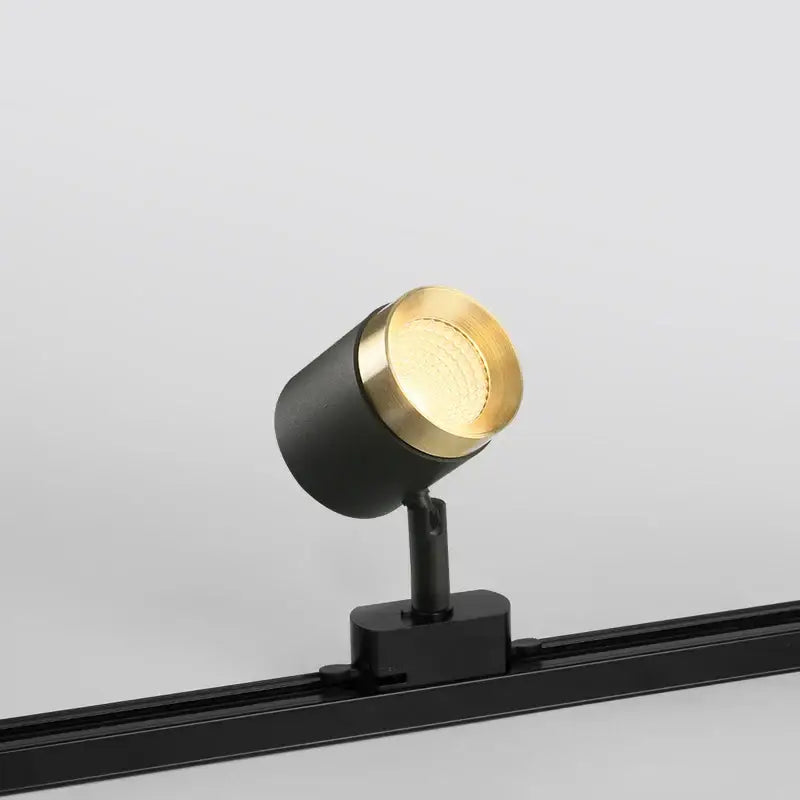 Modern black led track spotlight with a gold circular head and matte black base for kitchen rail ceiling lighting
