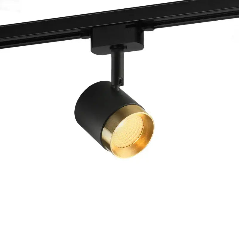 Modern black led track spotlight with matte black cylindrical body and polished brass ring for kitchen ceiling lighting