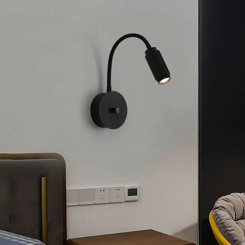 Modern black led wall lamp with adjustable focus and flexible gooseneck arm mounted on the wall for bedroom use