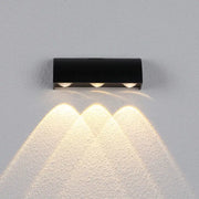Modern black led wall lamp with three warm white bulbs emitting focused beams in a sleek rectangular lighting fixture