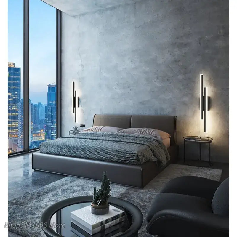 Modern black led wall lamp with dual light bars complements a sleek black leather platform bed and gray upholstered headboard