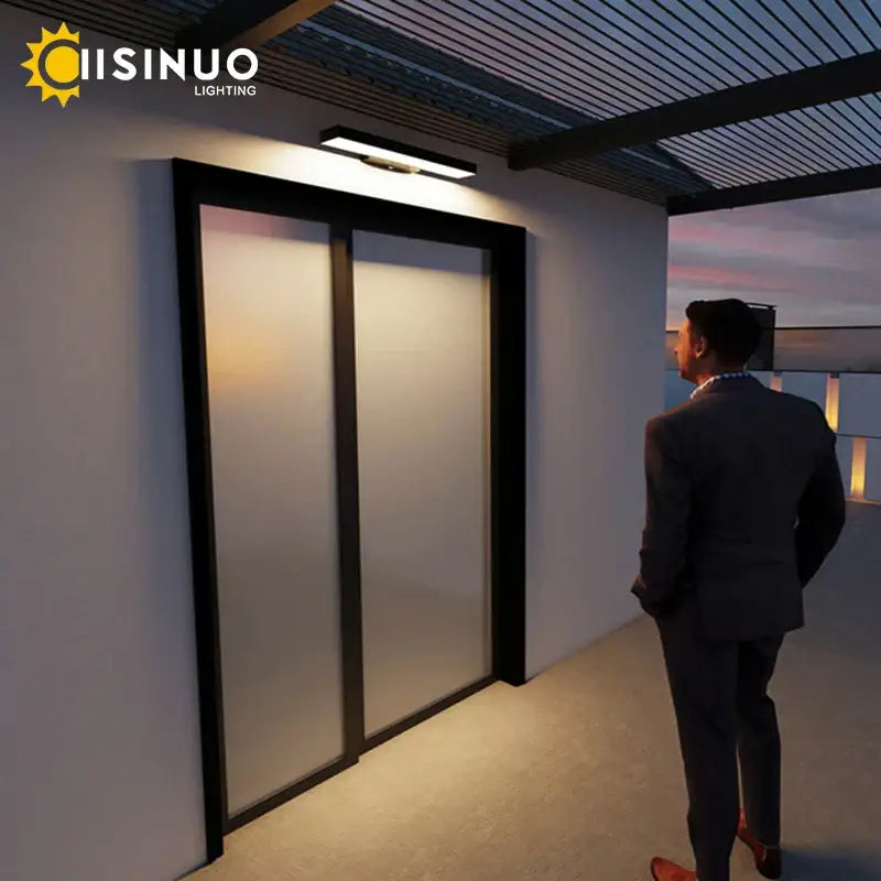 Modern black led wall light with dusk dawn motion sensor mounted beside black-framed sliding glass doors with frosted panels