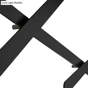 Modern black wall light with x-shaped matte metal leg and bulb included featuring a sleek bulb base design