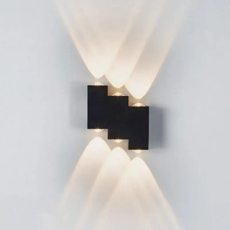 Modern black geometric wall lamp with four angled ip65 led lights casting warm soft beams for garden decorbites ip65 led wall use