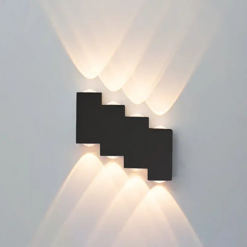 Modern black stepped wall lamp with four warm white decorbites ip65 led lights casting soft angled beams