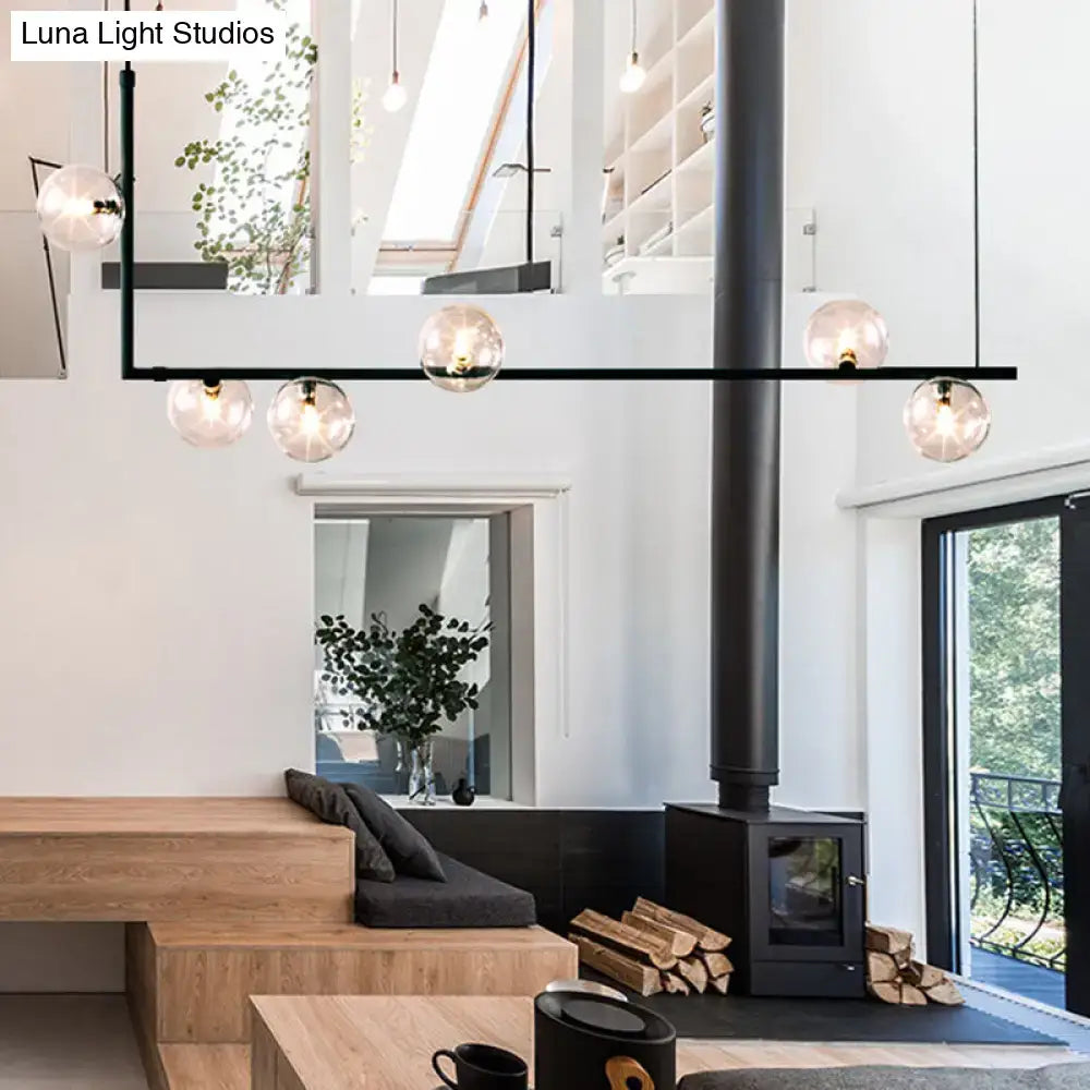 Modern black metal chandelier with five spherical glass shade globes for dining room island pendant lighting