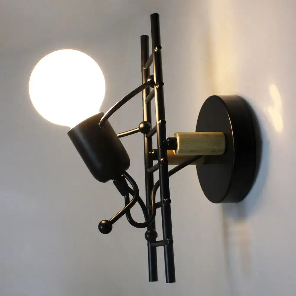 Modern black little man led wall light featuring a black metal sconce with brass accent and adjustable spotlight