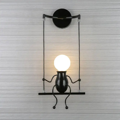 Modern black metal swing-style man led wall light with glowing head-shaped bulb for bedroom wall lighting
