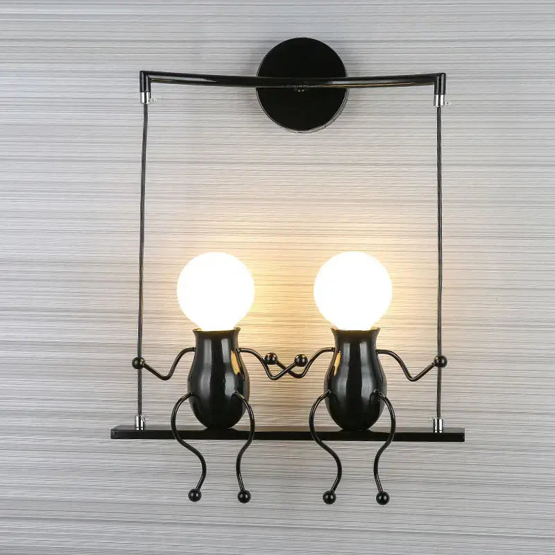 Modern black metal wall light with two whimsical man led wall figurines and glowing spherical led bulbs for bedroom