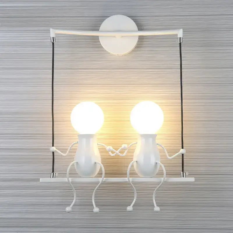 Modern black little man led wall light with two whimsical figure-shaped bulbs holding hands mounted on white wall