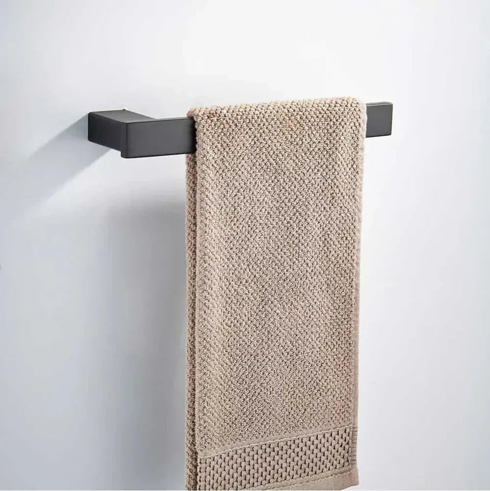 Beige textured towel hanging from a matte black rectangular bar in a decorbites black matte hardware set for bathroom decor