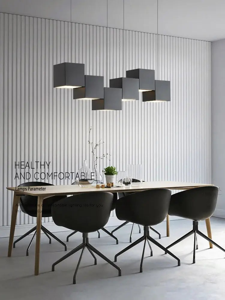 Modern black matte cube pendant lights with geometric design suspended above a dining table for decorbites geometric dining room