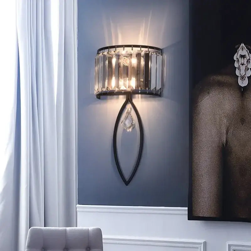 Modern black metal led wall lamp featuring vertical crystal bars and a teardrop-shaped crystal pendant for living room