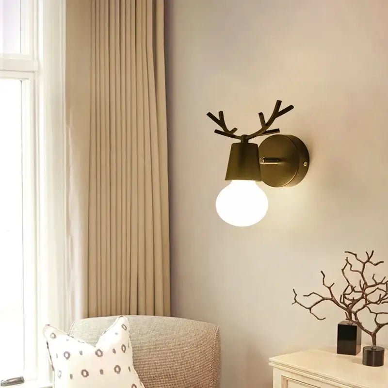 Modern black metal deer head led wall lamp with antler-shaped matte bronze sconce and exposed bulb for bedroom lighting