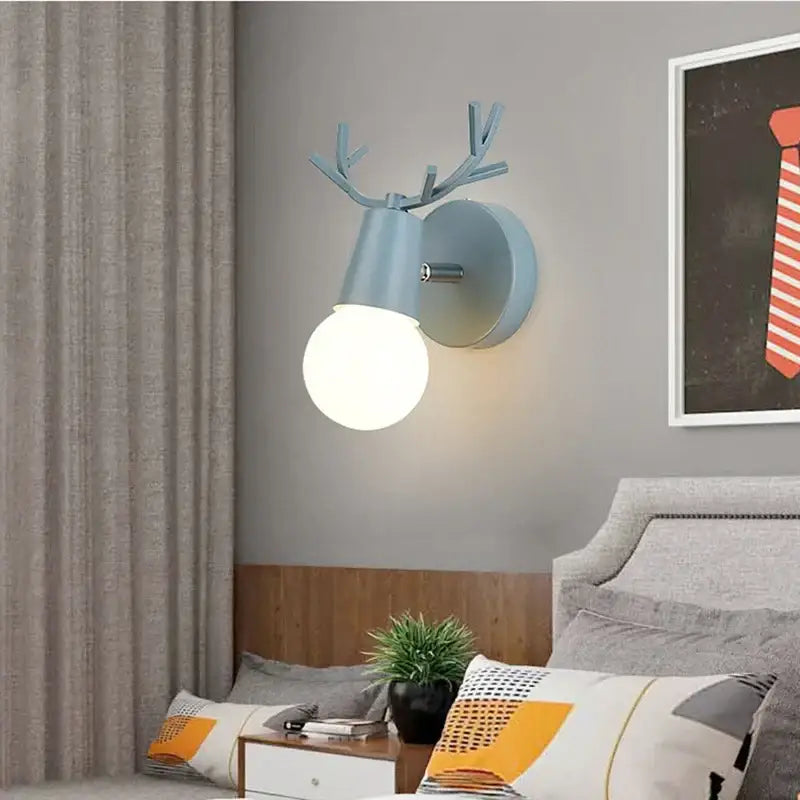 Light blue deer head led wall lamp with round frosted bulb in modern black metal design for bedroom sconce