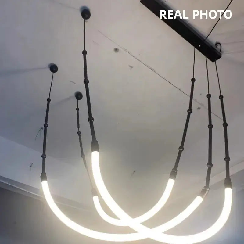 Modern black metal pendant lights with curved glowing white led strips ideal for living room decorbites bamboo pendant style