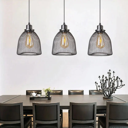 Modern black metal mesh pendant light chandelier with exposed filament bulbs hanging above dining table