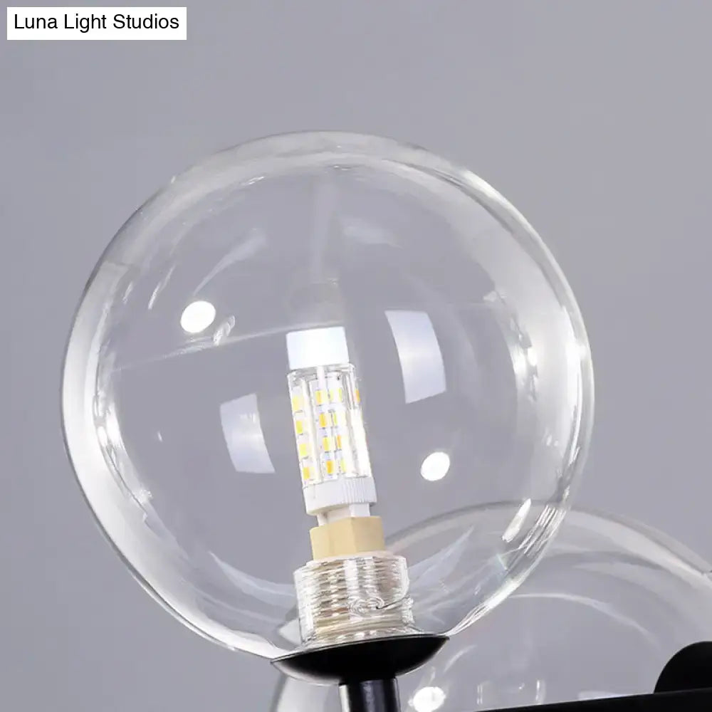 Clear glass globe with a white led bulb and yellowish leds in a modern black metal pendant light fixture ceiling light