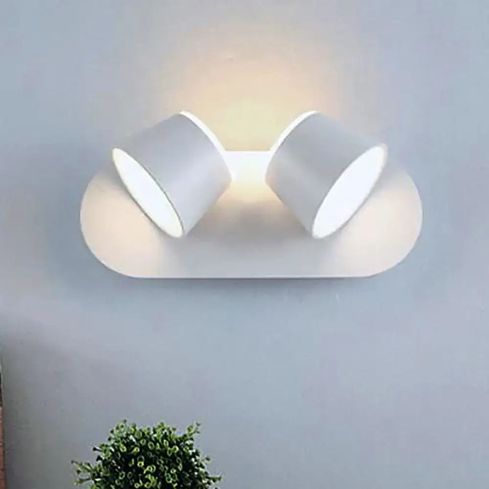 Modern white wall-mounted sconce with two adjustable cylindrical lights featuring metal shade and compact fixture width