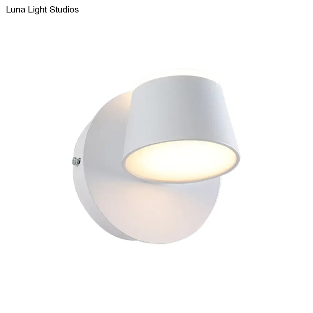 Modern black metal shade wall sconce with white cylindrical fixture and shade height providing soft ambient lighting