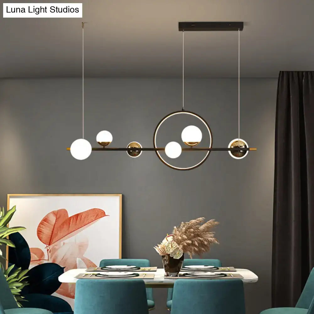Modern black metal pendant light with spherical glass globes and gold accents for dining room illumination