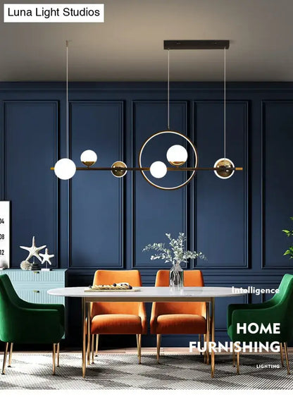 Modern black metal pendant light with spherical glass globes and brass frame for dining room illumination