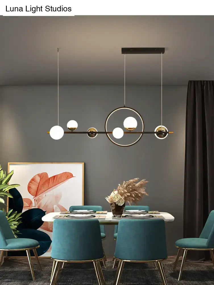 Modern black metal pendant light with sleek frame and spherical white glass shades for dining room lighting
