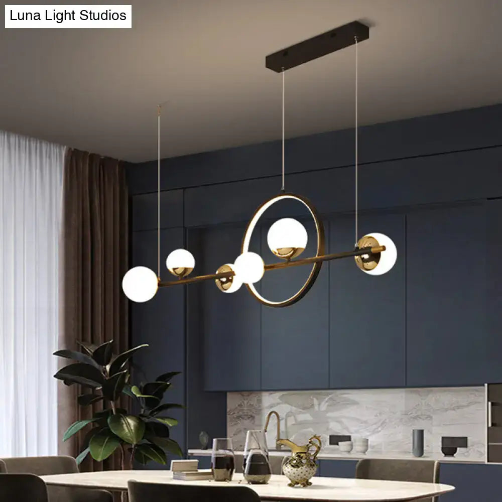 Modern black metal pendant light with gold-toned spherical glass globes and minimalist design for dining room