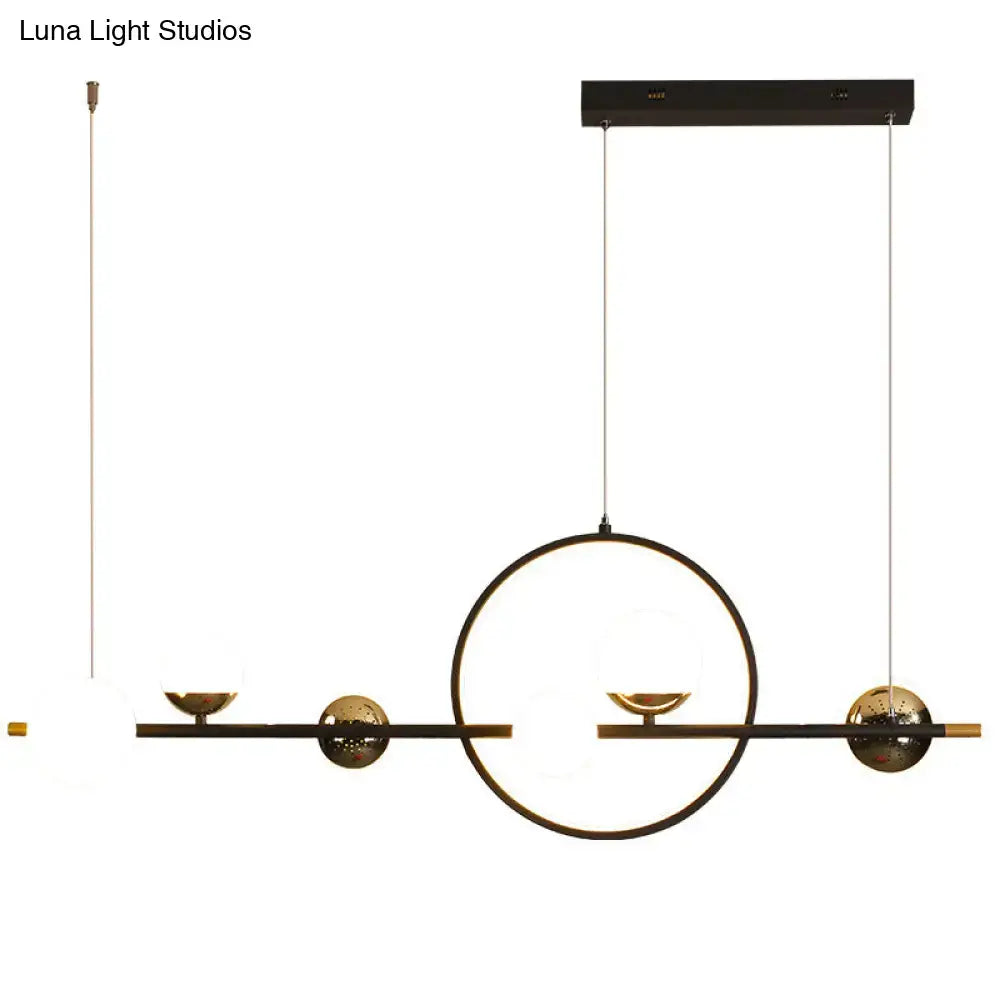 Modern black metal pendant light with spherical glass accents and gold geometric frame for dining room lighting